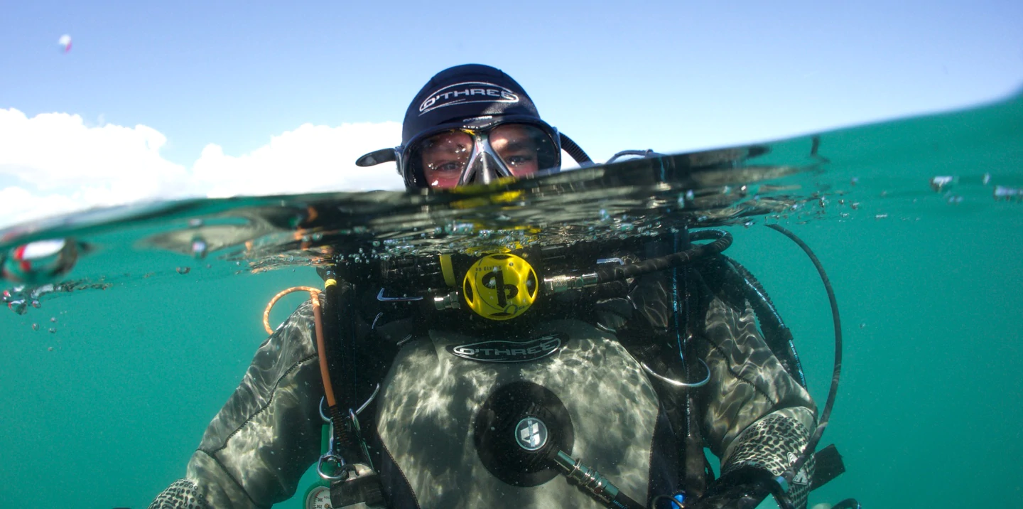 AP Diving rebreather diver with underwater camera near a wreck